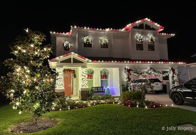 Luxury home Christmas light installation with wreaths and roofline lighting