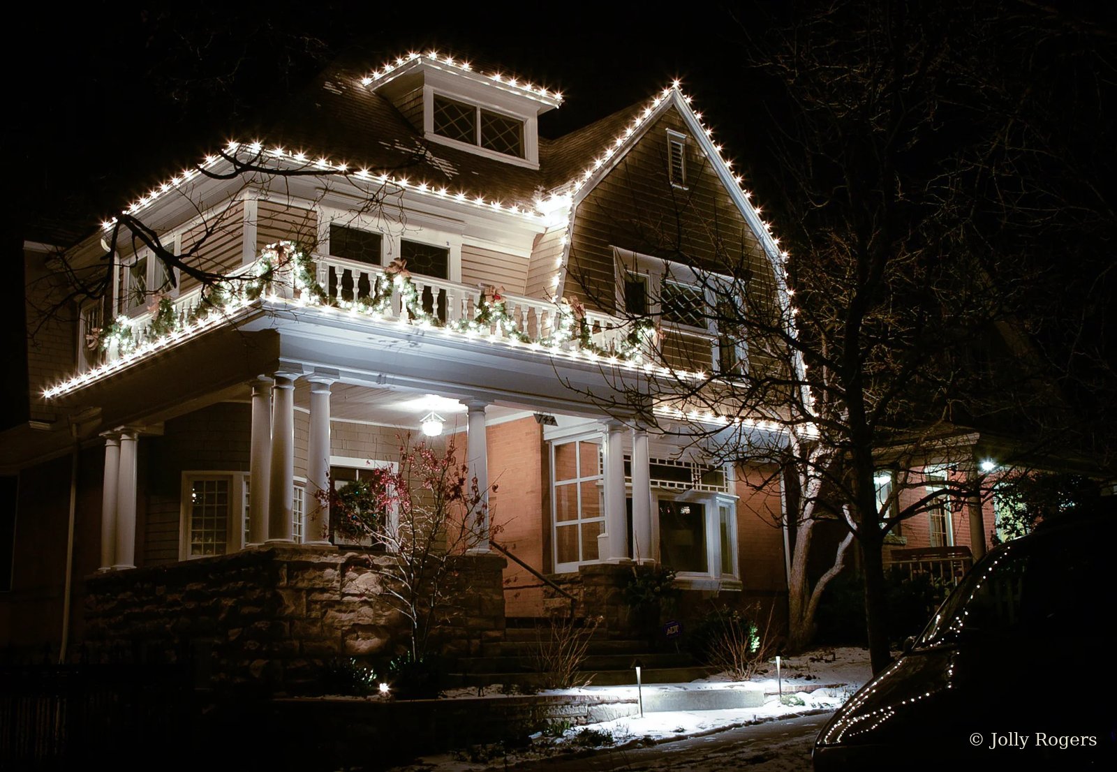 Historic home warm white roofline lighting and garland