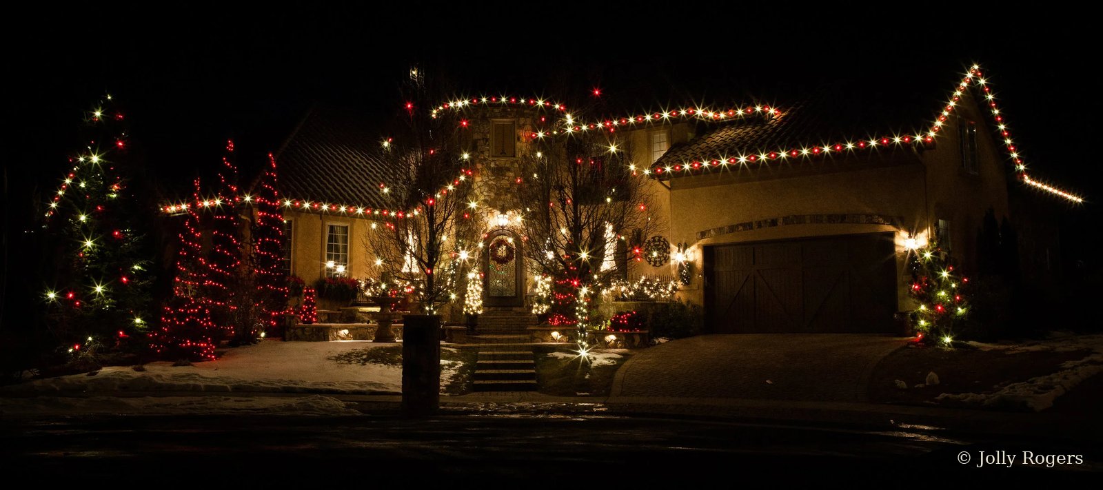 Red and white Christmas lights luxury home with lit trees