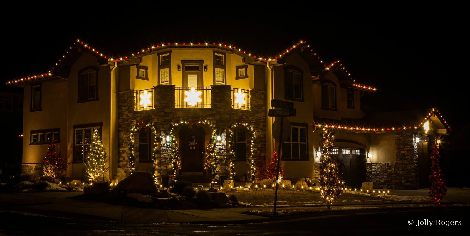 Red and warm white roofline with garland and snowflake accents